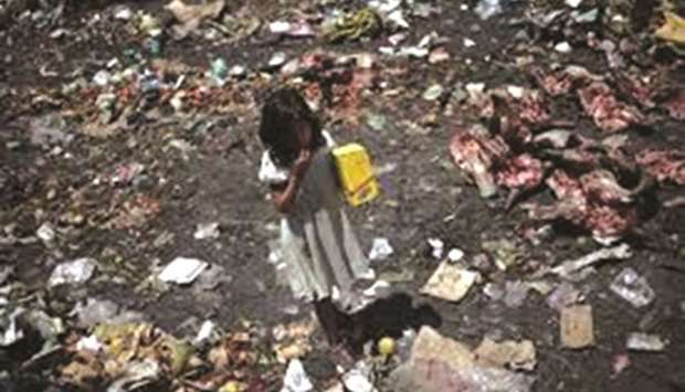 File photo: A girl walks amid garbage from La Terminal food market in Guatemala City.
