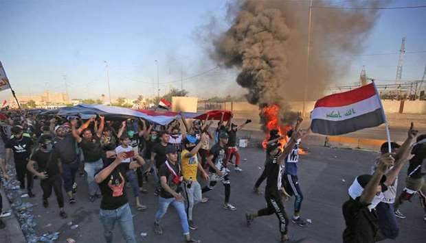 Iraqi protesters take part in a demonstration against state corruption, failing public services, and unemployment, in the Iraqi capital Baghdad's central Khellani Square