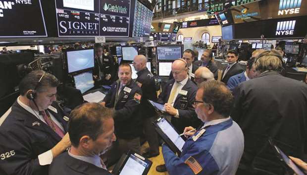 Traders work at the New York Stock Exchange (file). Investors are preparing for more cautious capital investment outlooks from US companies as worries mount heading into earnings season about the possibility of an economic recession.