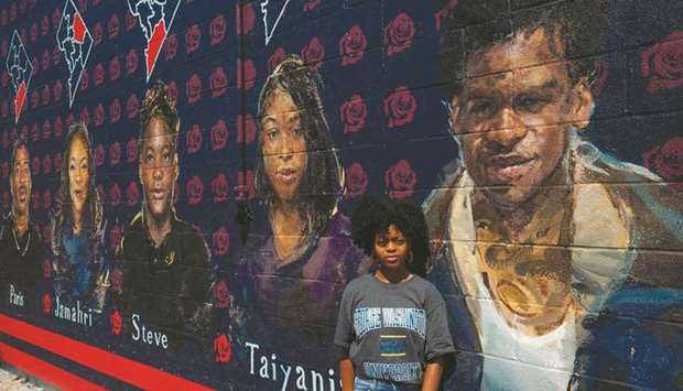 Lauryn Renford poses in front of a mural by Martin Swift depicting teenage gun violence victims in Washington, DC.