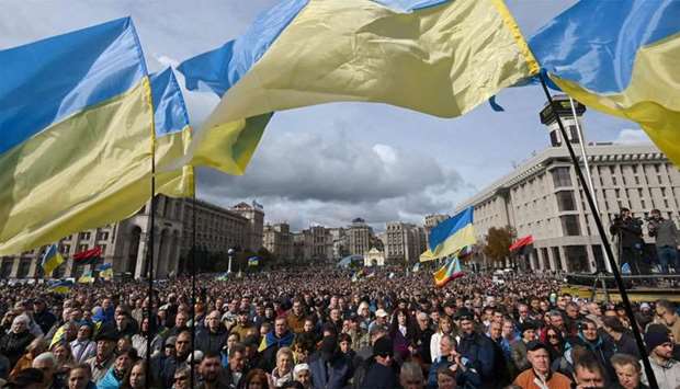 Demonstrators wave Ukraine national flags as they gather in central Kiev to protest broader autonomy for separatist territories, part of a plan to end a war with Russian-backed fighters.