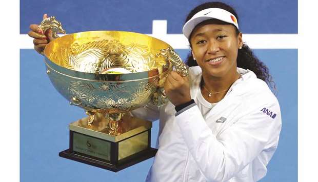 Naomi Osaka of Japan celebrates winning China Open with her trophy yesterday. (Reuters)