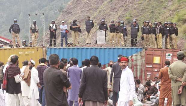 Police officers stand guard on shipping containers, used as an extra security measure to stop supporters of the Jammu and Kashmir Liberation Front (JKLF) during a u2018Freedom Marchu2019, heading towards the Line of Control (LoC) in Chakothi, Pakistan-administered Kashmir, against Indiau2019s decision to revoke the special status of Indian-administered Kashmir.