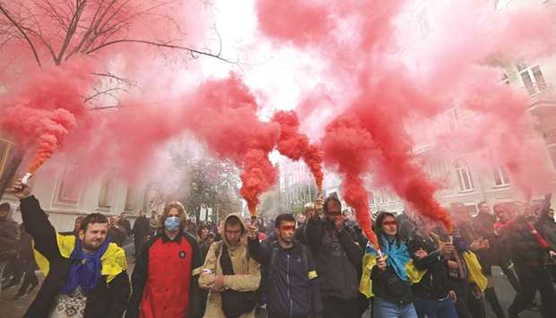 Demonstrators hold smoke grenades as they gather in central Kyiv to protest broader autonomy for separatist territories, part of a plan to end a war with Russian-backed fighters.