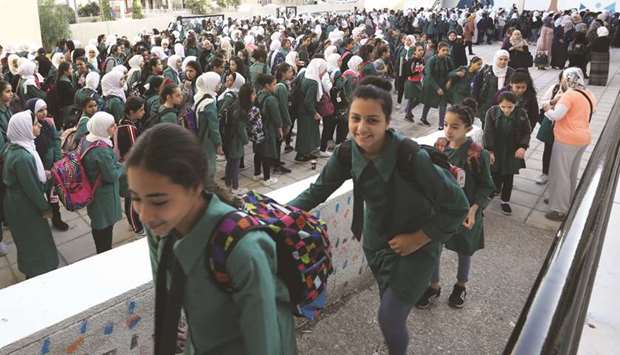 Students line up to enter their classrooms at one of the public schools during the first day after the end of the teachersu2019 one-month strike in Amman, yesterday.