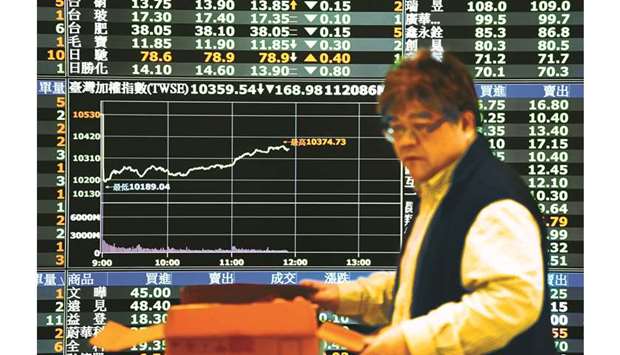A man opens a box with lunch in front of a monitor showing stock movements at the Taiwan Stock Exchange in Taipei (file). Last month, Taiwanu2019s markets received about $2.9bn of foreign investment, on optimism over its economy, as a growing number of local firms were shifting their factories back home from mainland China, seen as aiding their export revenues.