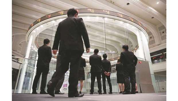 Visitors watch stock prices at the Tokyo Stock Exchange. The Nikkei 225 closed up 1.0% to 21,587.78 points yesterday.