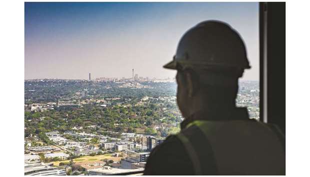 A construction worker looks out towards the Central Business District on the city skyline from inside The Leonardo, currently Africau2019s tallest building, in the Sandton district of Johannesburg (file). Moodyu2019s is the only major rating company still to assess South Africau2019s debt at investment grade.