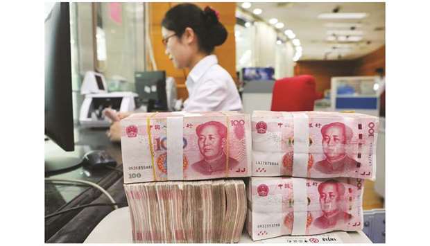 An employee counts 100-yuan notes at a bank in Nantong, Jiangsu province. Chinese regulators have been trying to boost bank lending and lower corporate financing costs for over a year, but the pick-up in loan growth has been modest compared to previous rounds of stimulus, and economic activity has continued to slow.