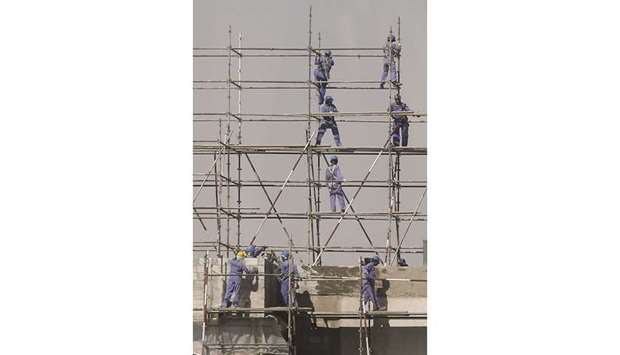 Labourers install scaffolding at a construction site in Doha. Building permits data is of particular importance as it is considered an indicator for the performance of the construction sector which in turn occupies a significant position in the national economy.