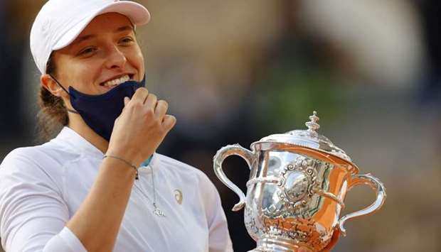 Poland's Iga Swiatek celebrates with the Suzanne Lenglen trophy during the podium ceremony after winning the women's singles final tennis match against Sofia Kenin of the US, at the Philippe Chatrier court, on Day 14 of The Roland Garros 2020 French Open tennis tournament in Paris