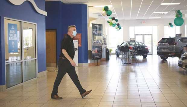 An employee wears a protective mask while working at a Honda Motor Co dealership in Southfield, Michigan. Private payrolls increased by 749,000 jobs this month after rising 481,000 in August, the ADP National Employment Report showed.