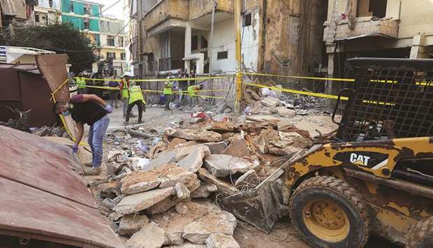Workers clean the site of a fuel tank explosion that occurred in the Al-Tariq al-Jadida neighbourhood of Beirut, yesterday.