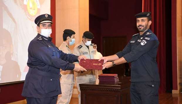 Brig Mohamed Abdullah al-Shahwani presents certificate to a graduate