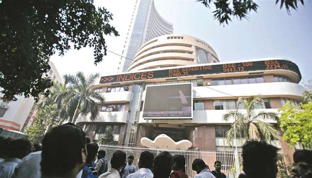 People monitor market news outside the Bombay Stock Exchange building in Mumbai (file). The S&P BSE Sensex climbed 1.7% to 38,697.05, while the NSE Nifty 50 index advanced by 1.5% yesterday.