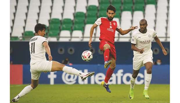 Al Sadd forward Baghdad Bounedjah (L) vies for the ball with Persepolisu2019 midfielder Bashar Resan (C) during their AFC Champions League Round of 16 match on September 27 in Doha.