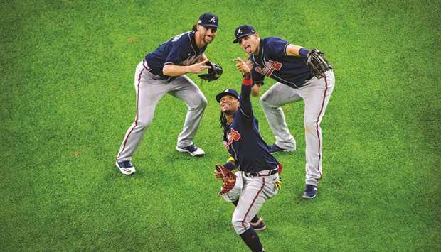 Atlanta Braves centre fielder Ronald Acuna Jr (centre) and right fielder Charlie Culberson and left fielder Austin Riley (right) celebrate by pretending to take a selfie after defeating the Los Angeles Dodgers in game one of the 2020 NLCS at Globe Life Field.  (USA TODAY Sports)