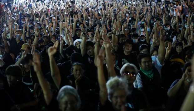 Pro-democracy demonstrators flash the three-fingers salute as they gather during a Thai anti-government mass protest, on the 47th anniversary of the 1973 student uprising, in Bangkok, Thailand.