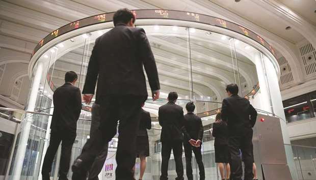 Visitors watch share prices at the Tokyo Stock Exchange. The Nikkei 225 closed up 0.1% to 23,626.73 points yesterday.