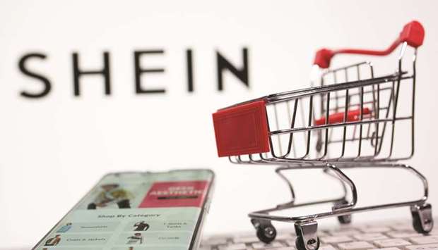 A keyboard and a shopping cart are seen in front of a displayed Shein logo in an illustration picture. Shein has become the largest, purely online, fashion company in the world measured by sales of self-branded products, according to Euromonitor.