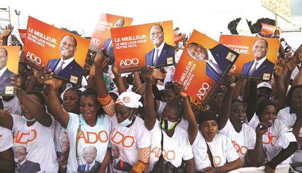 Supporters of presidential candidate Alassane Ouattara of the ruling RHDP coalition party hold signs during a campaign rally for the October 31 presidential election, in Abidjan, yesterday.