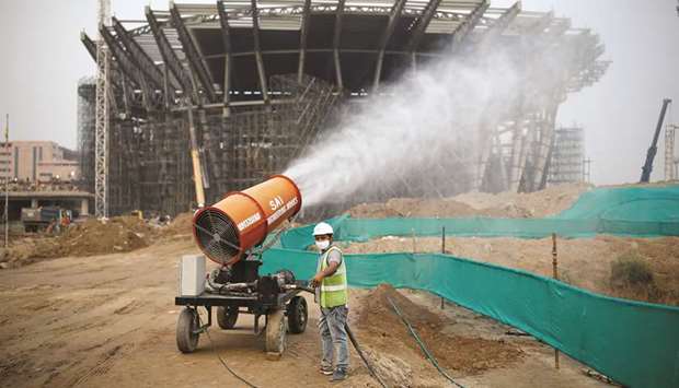 A worker operates an anti-smog gun at a construction site in New Delhi.