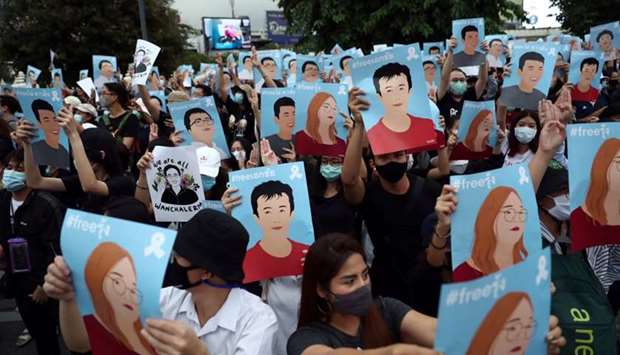 Pro-democracy demonstrators hold posters of protest leaders who have been arrested during an anti-government protest, in Bangkok, Thailand