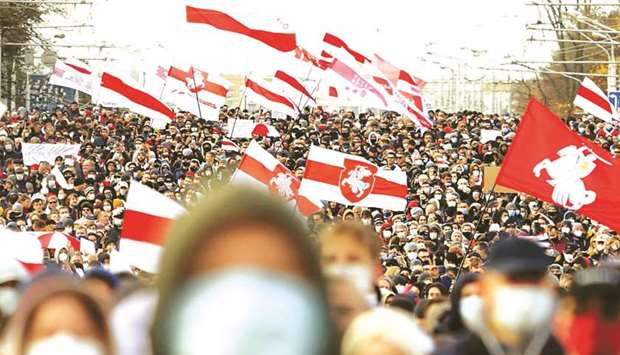 Opposition supporters, carrying former white-red-white flags of Belarus, parade through the streets in Minsk.