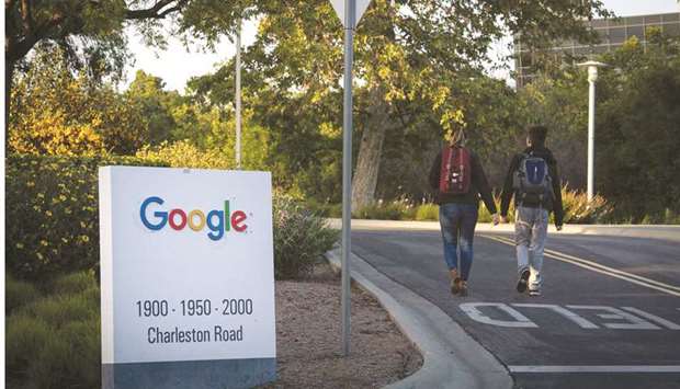 Pedestrians walk past a signage at Google headquarters in Mountain View, California. The US Justice Department lawsuit claims that Google acted unlawfully to maintain its position in search and search advertising on the Internet.