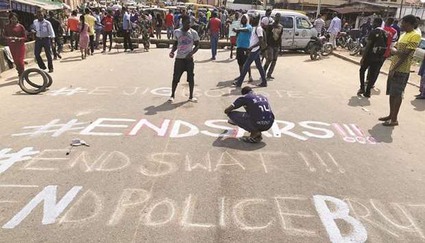 A demonstrator paints u2018End Sarsu2019, referring to the Special Anti-Robbery Squad police unit, on a street during a protest demanding police reform in Lagos, yesterday.