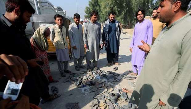 Afghan people stand over abandoned shoes of those who attended collecting tokens needed to apply for the Pakistan visa in Jalalabad, Afghanistan. Reuters