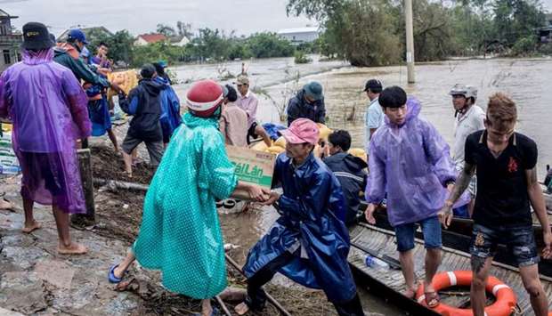 Local residents and volunteers deliver aid packages to residents affected by heavy flood in Quang An Commune, Thua Thien Hue, Vietnam
