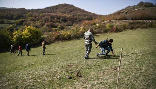Members of the Karabakh Ministry of Emergency Situations search for unexploded cluster bombs on the outskirts of Stepanakert yesterday, during the ongoing fighting between Armenia and Azerbaijan over the breakaway region of Nagorno-Karabakh