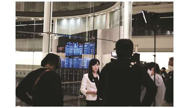 Members of the media work near a screen displaying share prices inside the Tokyo Stock Exchange. Markets hit the trifecta this month, with exchanges on three continents around the world going down; Euronext was the latest, following the Mexican bourse and Tokyo Stock Exchange.