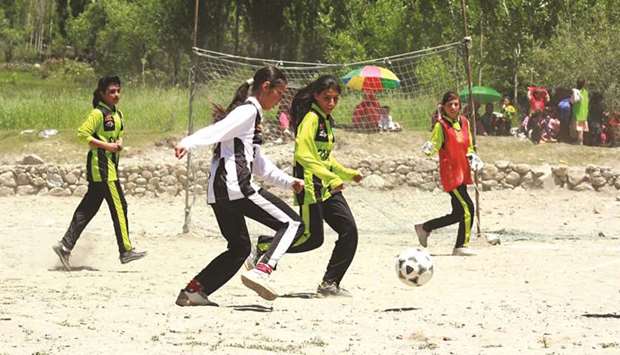In this July 7, 2020, picture, young women play football in Karimabad, Pakistan. (Thomson Reuters Foundation/Karishma Ali)