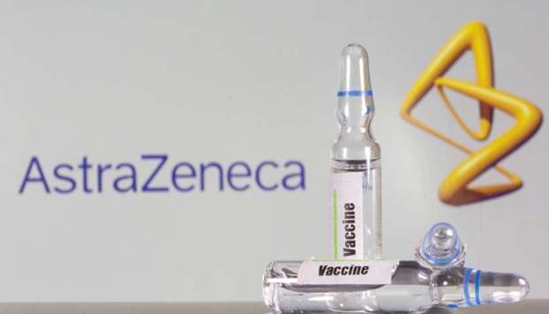 A test tube labelled with the Vaccine is seen in front of AstraZeneca logo in this illustration taken, September 9.