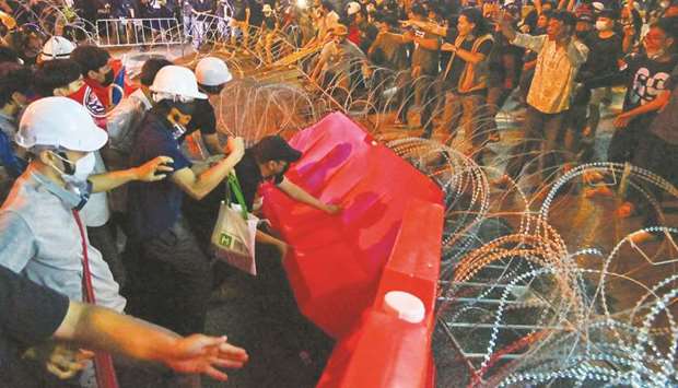 Pro-democracy protesters tear down sections of a barricade during an anti-government rally in Bangkok yesterday.