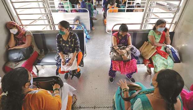 Women wearing protective face masks travel in a suburban train in Mumbai yesterday. Authorities resumed train services for women passengers during non-peak hours yesterday.