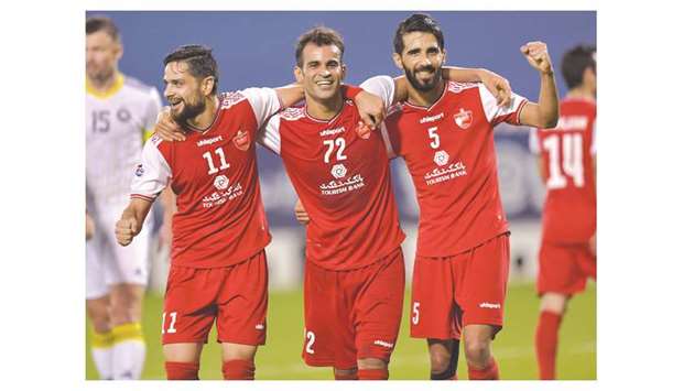 (From left) Persepolis players Kamal Kamyabinia, Isa al-Kasir and Bashar Resan celebrate after al-Kasir scored a goal during the AFC Champions League quarter-final against Pakhtakor at Jassim Bin Hamad Stadium on Wednesday. PICTURES: Noushad Thekkayil