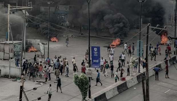 People are seen near burning tires on the street, in Lagos, Nigeria