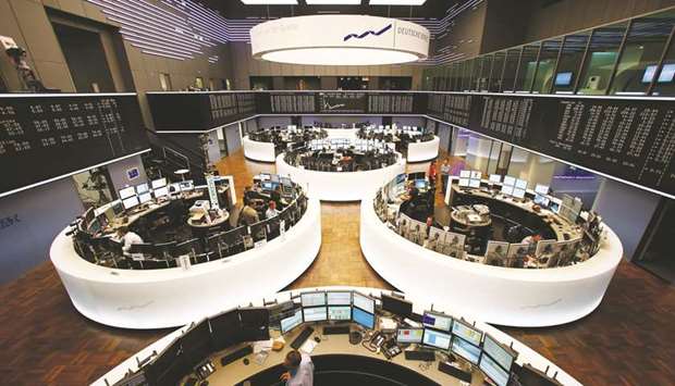 Traders monitor data on computer screens at the Frankfurt Stock Exchange. The DAX 30 closed up 0.8% to 12,645.75 points yesterday.