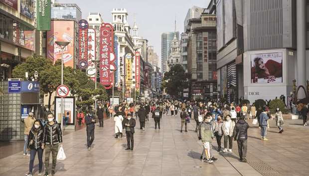 Shoppers and pedestrians wearing protective masks walk past stores on Nanjing Road in Shanghai. Chinau2019s top policy makers meet next week to hammer out the countryu2019s future economic blueprint, offering clues on how the leadership plans to pivot the worldu2019s second-largest economy to be more self-sufficient.