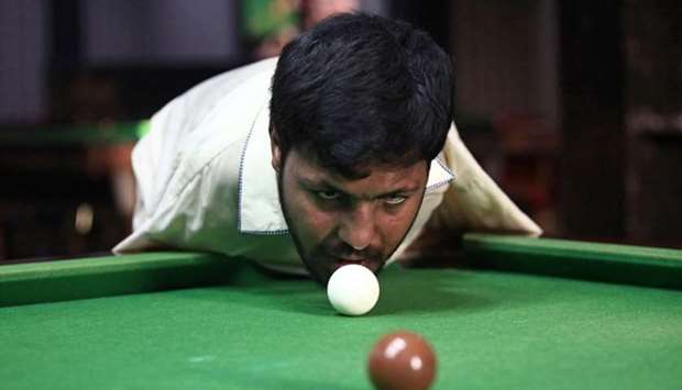 Muhammad Ikram, 32, who was born without arms, plays snooker with his chin at a local club in Samundri, Pakistan