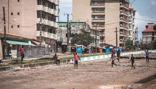 Protesters gesture, as they continue to throw stones and block roads during mass protests after preliminary results were released in Conakry, yesterday.