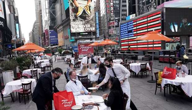 Servers deliver food to a table at a pop up restaurant set up in Times Square in New York
