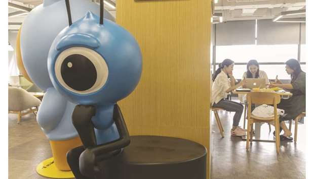 Employees sit at a table near an Ant Group Co mascot displayed at the companyu2019s headquarters in Hangzhou, China. T Rowe Price Group, UBS Asset Management and FMR, the parent of Fidelity Investments, are among the money managers angling for a piece of Ant Groupu2019s blockbuster initial public offering.