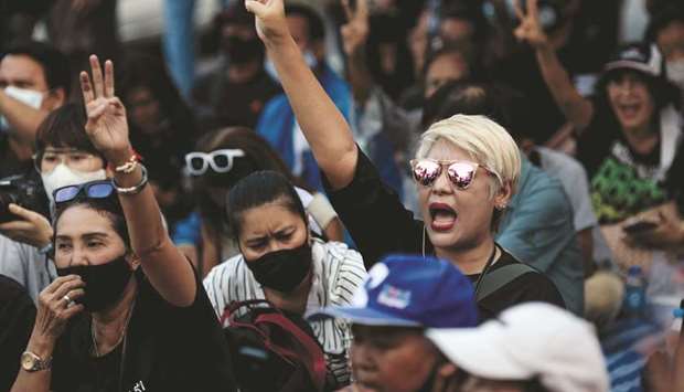 Pro-democracy protesters hold up the three-finger salute outside Bangkok Remand Prison yesterday, as they urged the release of protest leaders and other activists held at the facility following arrests during the ongoing demonstrations.