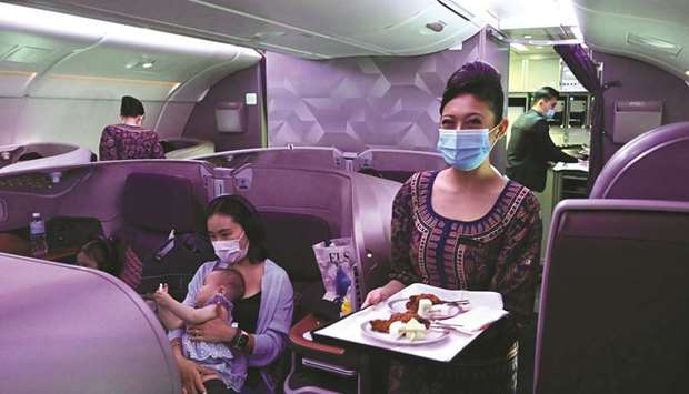 A Singapore Airlines stewardess smiles while serving food in business class during the inaugural lunch.