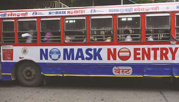 Passengers travel on a bus which has a precautionary message pasted on it against the spread of coronavirus, in Mumbai.