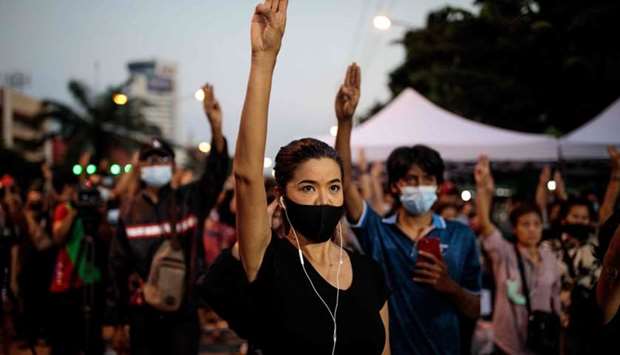 Pro-democracy protesters hold up the three-finger salute outside Bangkok Remand Prison in Bangkok on October 24, 2020, as they urged the release of protest leaders and other activists held at the facility following arrests during the ongoing demonstrations.